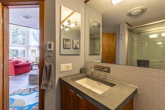 bathroom with vanity, an enclosed shower, and tile walls