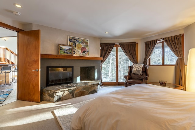 bedroom with carpet flooring, access to exterior, and a fireplace