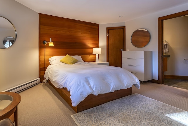 bedroom with baseboard heating, wooden walls, and carpet floors