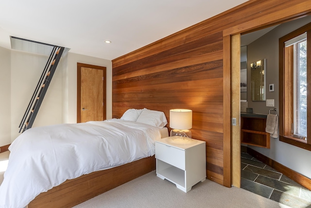 carpeted bedroom with wood walls