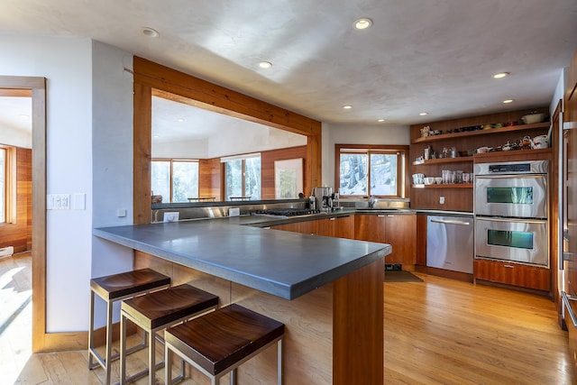 kitchen with a breakfast bar, kitchen peninsula, and stainless steel appliances