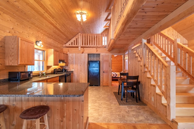 kitchen featuring wooden ceiling, wood walls, a peninsula, and black appliances