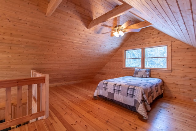 bedroom featuring wooden walls, light wood-type flooring, and lofted ceiling with beams