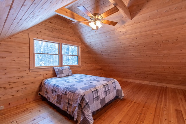 bedroom with vaulted ceiling with beams, light wood-style floors, a ceiling fan, wooden walls, and wooden ceiling