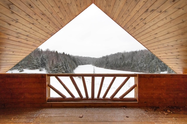 snow covered gate featuring a wooded view