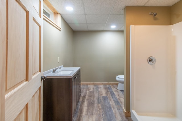 full bath featuring toilet, a paneled ceiling, wood finished floors, and vanity