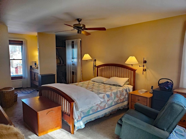 carpeted bedroom featuring radiator and ceiling fan