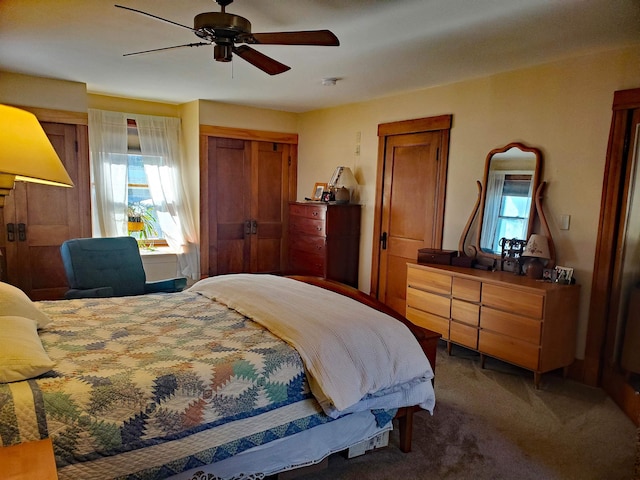 carpeted bedroom with ceiling fan and a closet