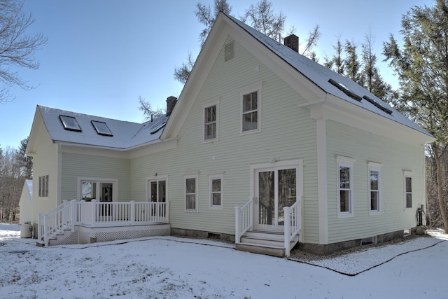 view of snow covered rear of property