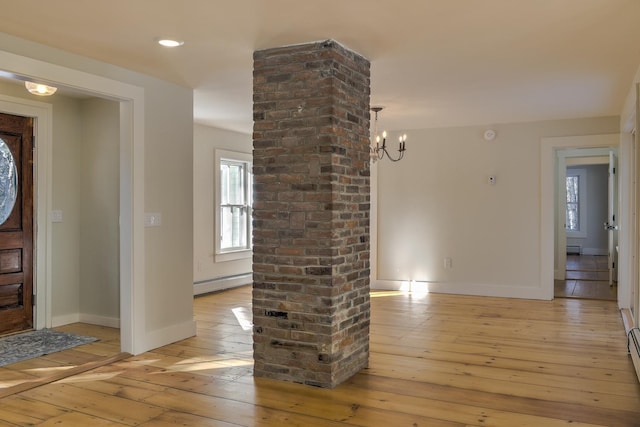 foyer with an inviting chandelier, light wood-type flooring, and a baseboard heating unit