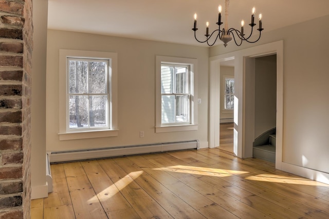 unfurnished dining area with light hardwood / wood-style flooring, a chandelier, and baseboard heating