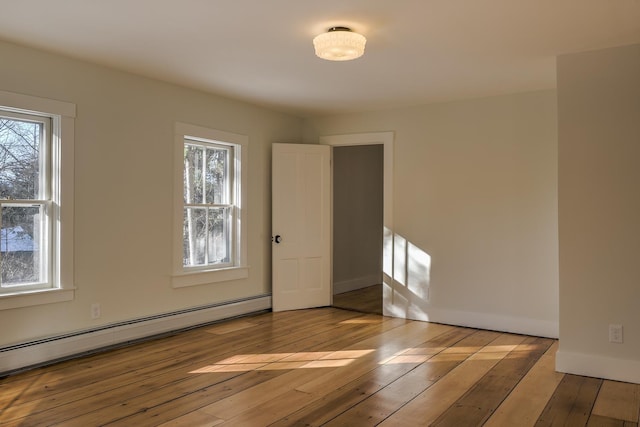 spare room featuring a baseboard radiator and light hardwood / wood-style floors