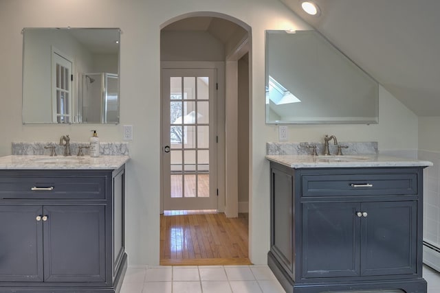 bathroom with walk in shower, tile patterned floors, a skylight, and vanity