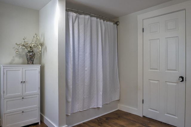 bathroom with hardwood / wood-style floors and shower / bath combination with curtain