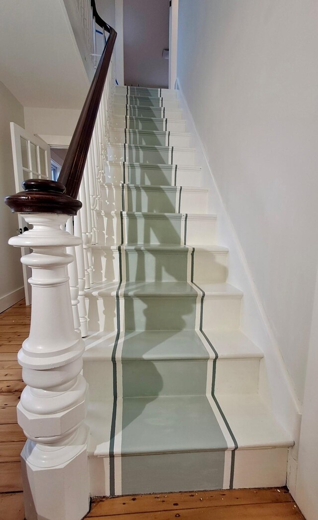 stairway with hardwood / wood-style flooring