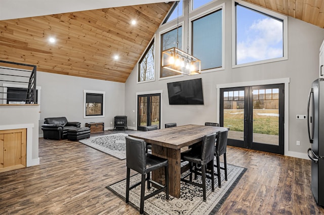 dining space featuring french doors, dark hardwood / wood-style flooring, high vaulted ceiling, wooden ceiling, and a wood stove