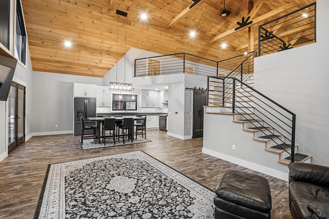 living room featuring a towering ceiling, wooden ceiling, and dark hardwood / wood-style floors