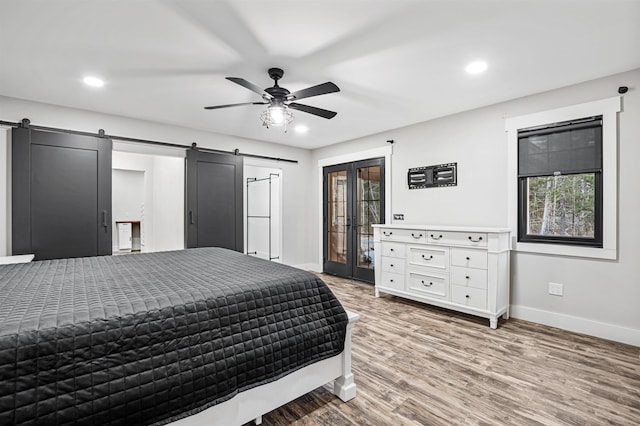 bedroom with access to exterior, ceiling fan, french doors, a barn door, and hardwood / wood-style flooring