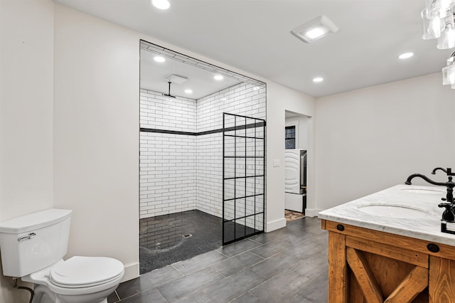 bathroom featuring vanity, toilet, and tiled shower