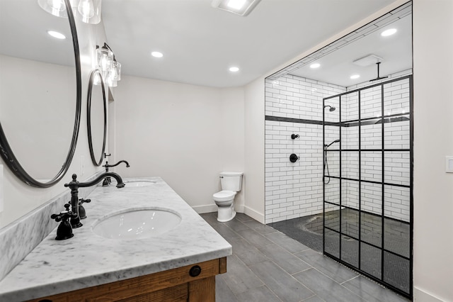 bathroom featuring a tile shower, vanity, and toilet