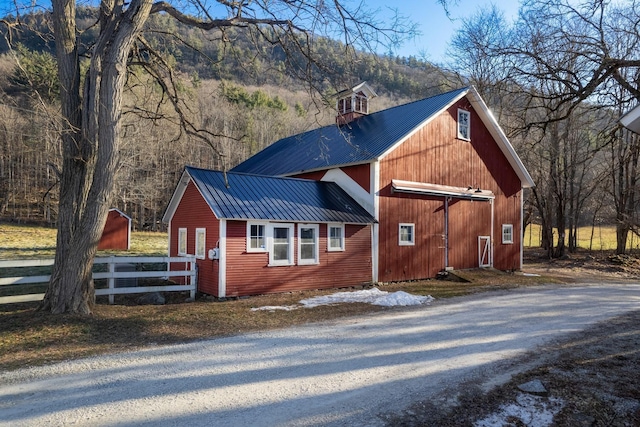 view of home's exterior featuring a mountain view and an outdoor structure