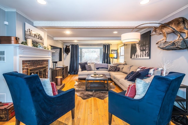 living room with ornamental molding, beam ceiling, and light hardwood / wood-style flooring