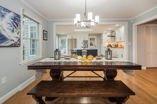 dining space with ornamental molding, wood-type flooring, a baseboard heating unit, and sink