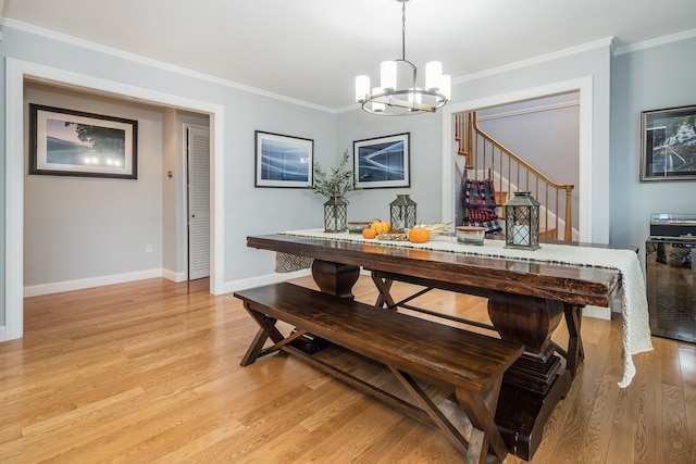 dining area with a notable chandelier, crown molding, and light hardwood / wood-style flooring