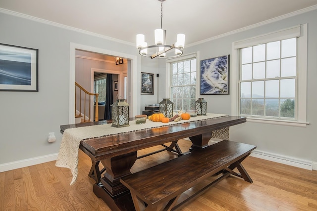 dining room featuring a baseboard radiator, ornamental molding, a notable chandelier, and light wood-type flooring