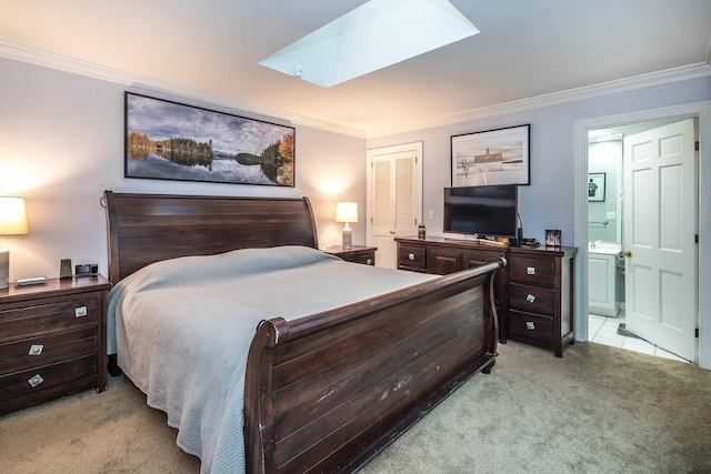 carpeted bedroom featuring crown molding, ensuite bathroom, and a skylight