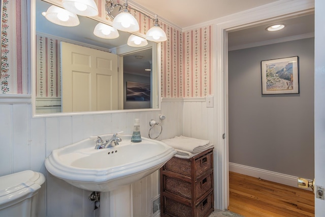 bathroom featuring hardwood / wood-style flooring, toilet, sink, and crown molding