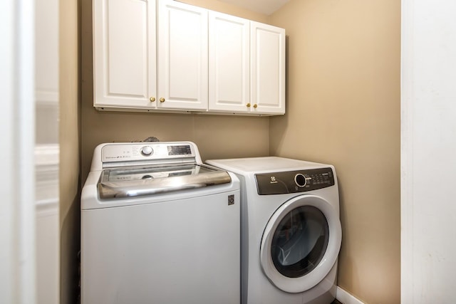 washroom featuring cabinets and independent washer and dryer