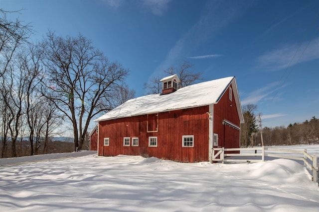 snow covered property with an outdoor structure