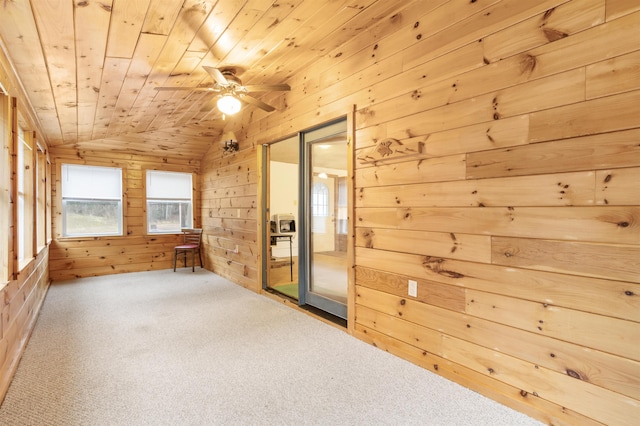 carpeted spare room featuring wooden walls, ceiling fan, wooden ceiling, and vaulted ceiling