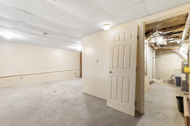 basement with electric water heater and a drop ceiling