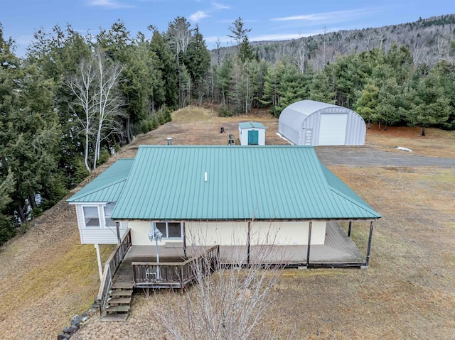 view of pool featuring a garage, an outdoor structure, and a deck