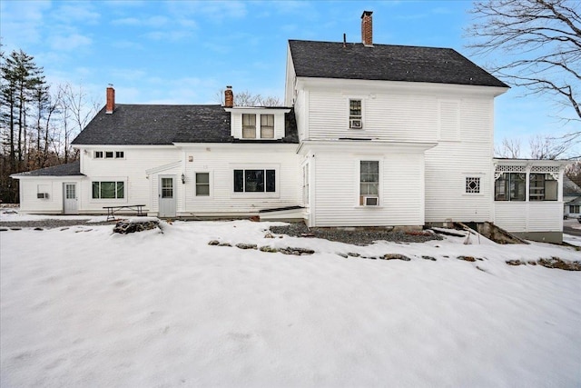 view of snow covered rear of property