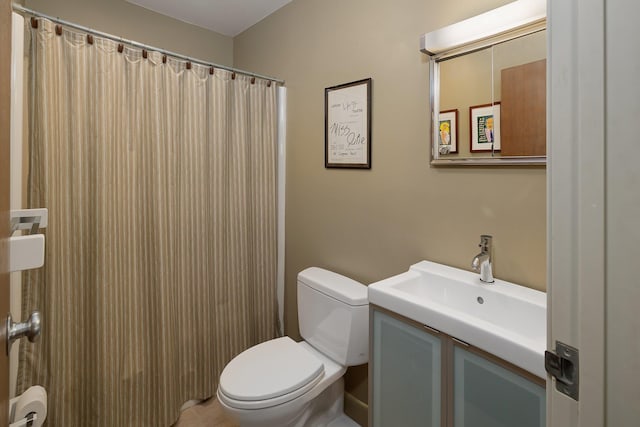 bathroom with curtained shower, vanity, and toilet