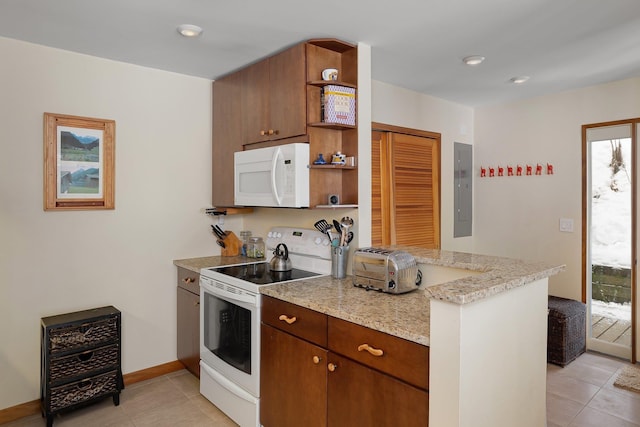 kitchen featuring light tile patterned floors, white appliances, kitchen peninsula, and electric panel