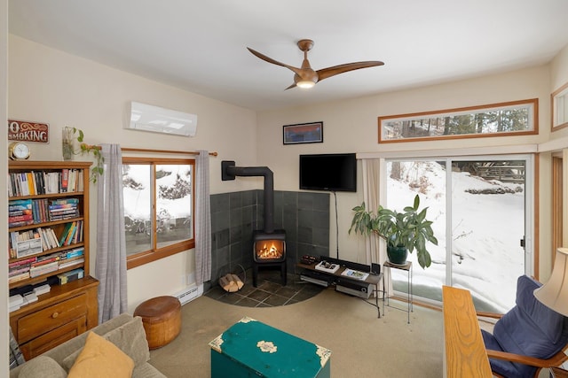 living area featuring carpet flooring, a wood stove, ceiling fan, a baseboard radiator, and a wall mounted air conditioner