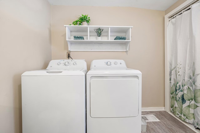 washroom featuring hardwood / wood-style flooring and washing machine and clothes dryer