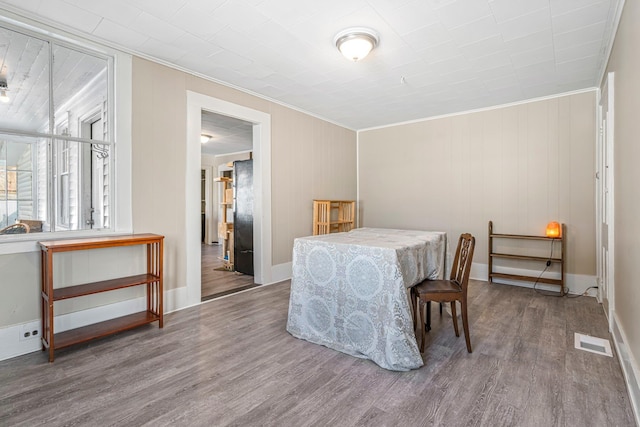 dining room featuring wood-type flooring and crown molding