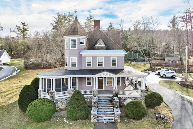 victorian house with a front lawn and covered porch