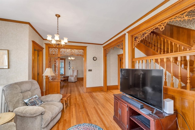 living room with crown molding, light hardwood / wood-style floors, and an inviting chandelier