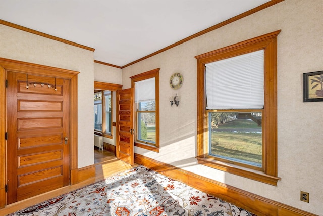 foyer with radiator, crown molding, and wood-type flooring