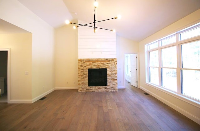 unfurnished living room with a chandelier, dark wood-type flooring, a fireplace, and vaulted ceiling