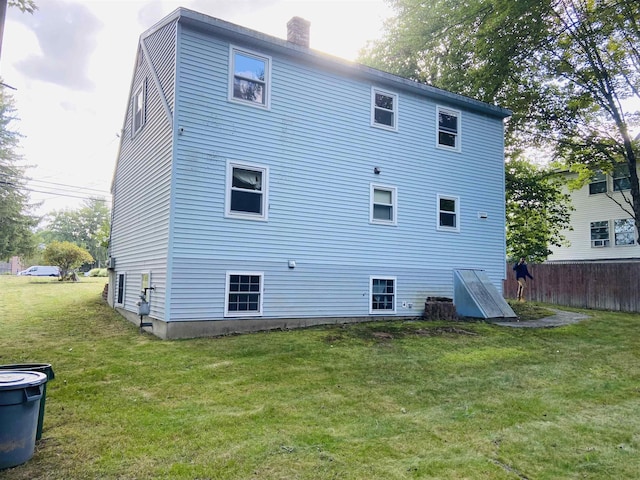 rear view of house featuring a lawn