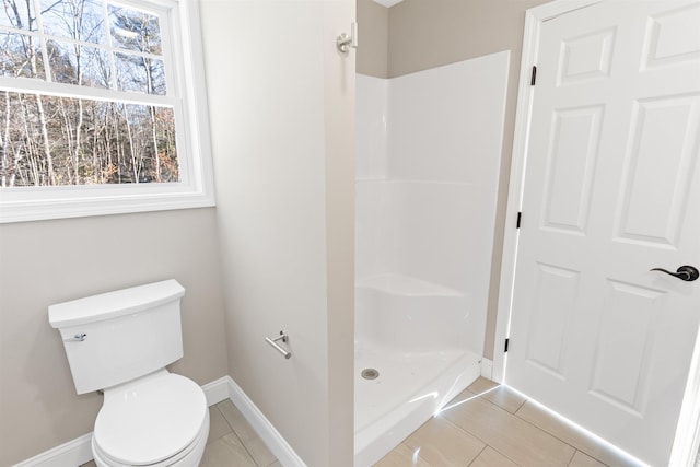 bathroom with tile patterned flooring, toilet, and walk in shower