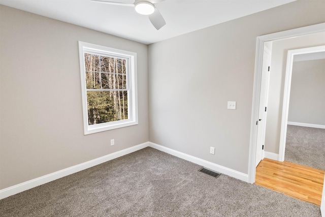 carpeted spare room with ceiling fan