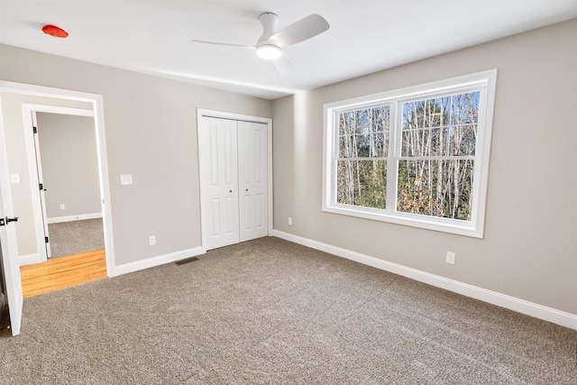 unfurnished bedroom featuring carpet flooring, ceiling fan, and a closet